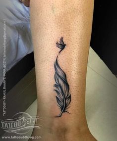 a black and white feather tattoo on the leg