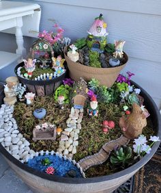 a potted planter filled with lots of plants and small gnome figurines