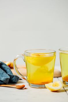 two cups filled with tea next to each other