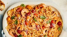 a plate of pasta with shrimp and tomato sauce