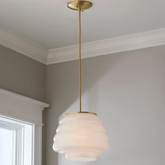 a light fixture hanging from the ceiling in a room with gray walls and white trim