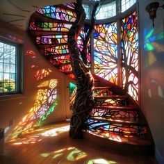 a spiral staircase with stained glass windows in the background and sunlight coming through it on the floor