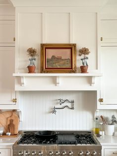 a stove top oven sitting inside of a kitchen next to white cabinets and counter tops