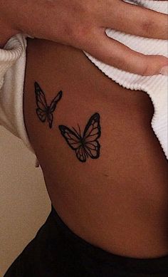 a woman with a butterfly tattoo on her stomach