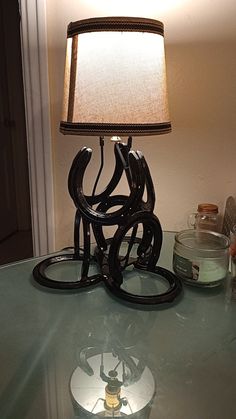 a lamp sitting on top of a glass table next to a jar and bottle opener