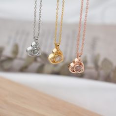 three different necklaces on a wooden table