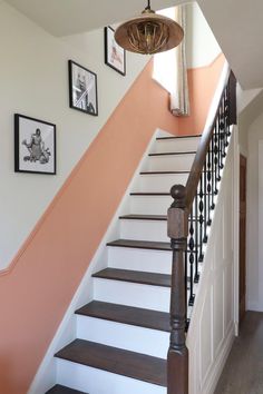 the stairs are painted white and brown with pink accents on each handrail in this entryway