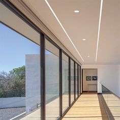 an empty hallway with glass walls and sliding doors