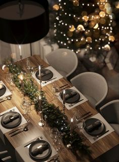 a table set for christmas dinner with silverware and candles