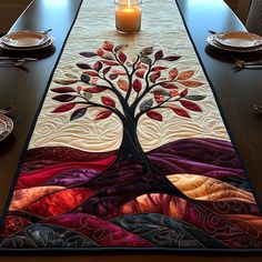 a table runner with a tree on it and a lit candle in the center, along with other place settings