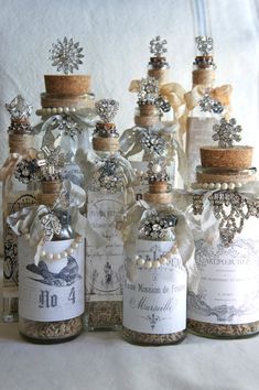 two bottles are sitting on a table next to some flowers and other things in front of them