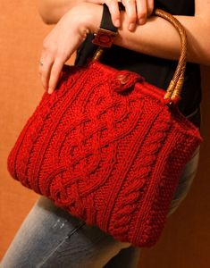 a woman holding a red knitted purse