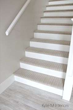 the stairs in this house are painted white and have chevroned carpet on them