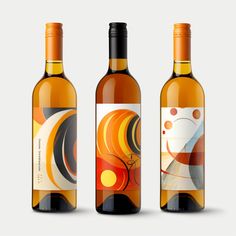 three bottles of wine with different designs on the front and back, one is empty