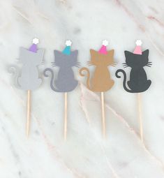 three cake toppers with cats on them sitting next to each other in front of a marble background