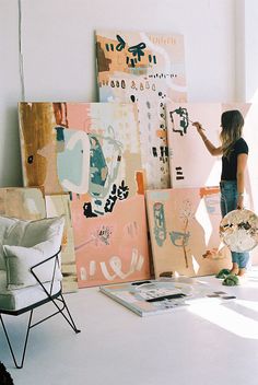 a woman is painting on canvass in an art studio