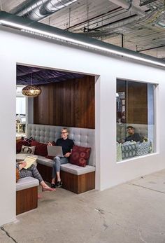 two people sitting on couches in an office