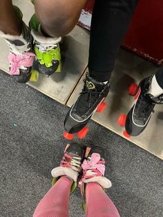 the legs and feet of two people wearing roller skates with pink bows on them