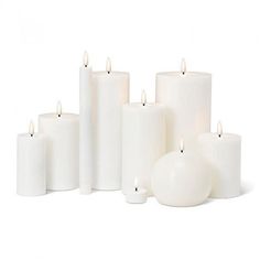 several white candles are lined up next to each other