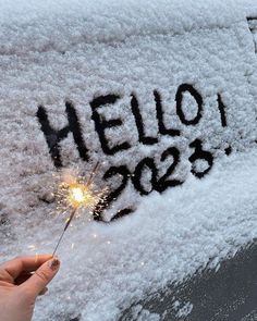 someone holding a sparkler in front of a car with the word hello 205 written on it