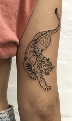 a black and white tiger tattoo on the arm