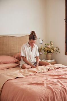 a woman sitting on top of a bed in a bedroom