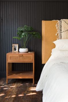 a bedroom with black walls and white bedding