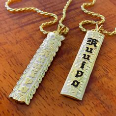 Please Allow 3-4 weeks for delivery. We've had so many requests for a Custom Hawaiian Heirloom Vertical Bar Pendant. You will treasure this beautiful piece done in a traditional Heirloom style. Choose from Black Enamel or Raised Gold Lettering. It's 10mm wide and 1-1/2" long. To keep the cost down we made this pendant in 14K Gold Plated over sterling silver. You have your choice of adding a flower or plain design. Add a special engraved message on the back for only $15 more. Includes 18" Chain. Hawaiian Necklace, Pineapple Earrings, Vertical Bar, Bone Pendant, Pave Pendant, Gold Lettering, Scroll Design, Bar Pendant, Gold Letters