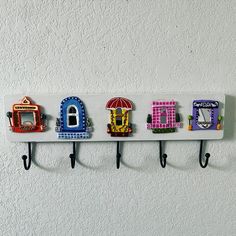 a row of colorful magnets mounted to a wall with hooks on each one side