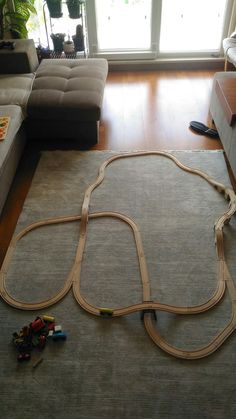 a toy train set laying on the floor next to a couch