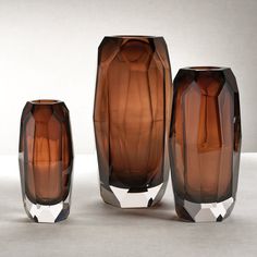 three brown glass vases sitting next to each other