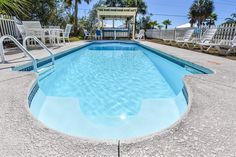 an empty swimming pool with chairs around it