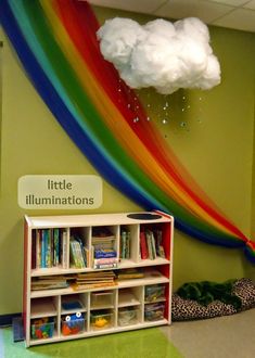 a rainbow wall hanging over a book shelf