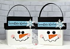 two bags with snowmen on them are sitting in front of a white brick wall