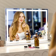 a woman is looking at her reflection in the mirror