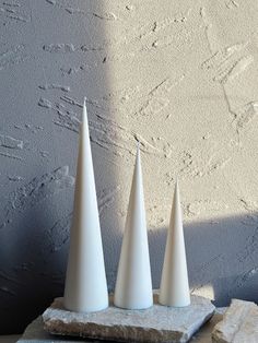 three white cones sitting on top of a rock