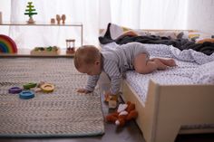 a toddler playing with toys on the floor in his bedroom, while another child watches