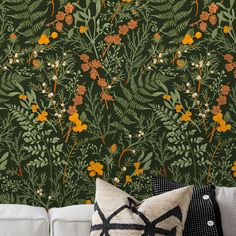 a living room with a white couch and green wallpaper that has orange flowers on it