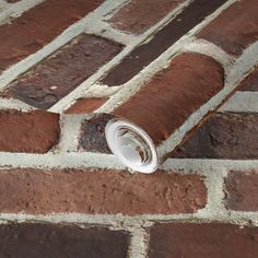 a brick wall with a rolled up roll of paper sticking out of the top and bottom