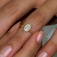 a close up of a person's hand with a diamond ring on their finger