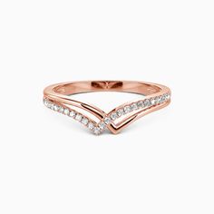 a rose gold ring with white diamonds on the band and an arrow design in the middle