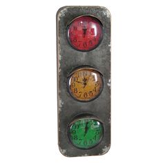 an old traffic light with three clocks on it