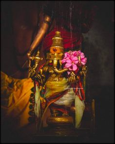 an image of a statue with flowers in the center and a candle on it's side