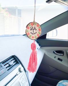 the interior of a car with a pink tassel hanging from it's dash board