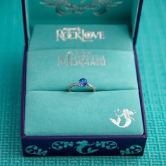 an engagement ring sits in a blue box