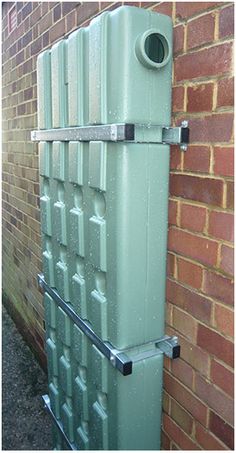 an old green radiator next to a brick wall