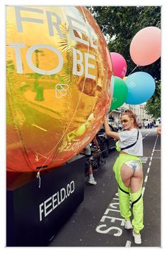 a woman in neon green pants holding balloons