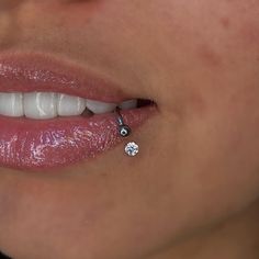 a woman's mouth with a diamond nose pin in her left side, and a white background