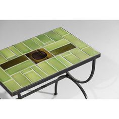 a small table with a green tile design on it's top and metal legs