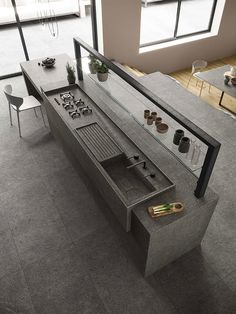 an aerial view of a modern kitchen and dining room with grey tile flooring, large windows, potted plants on the counter